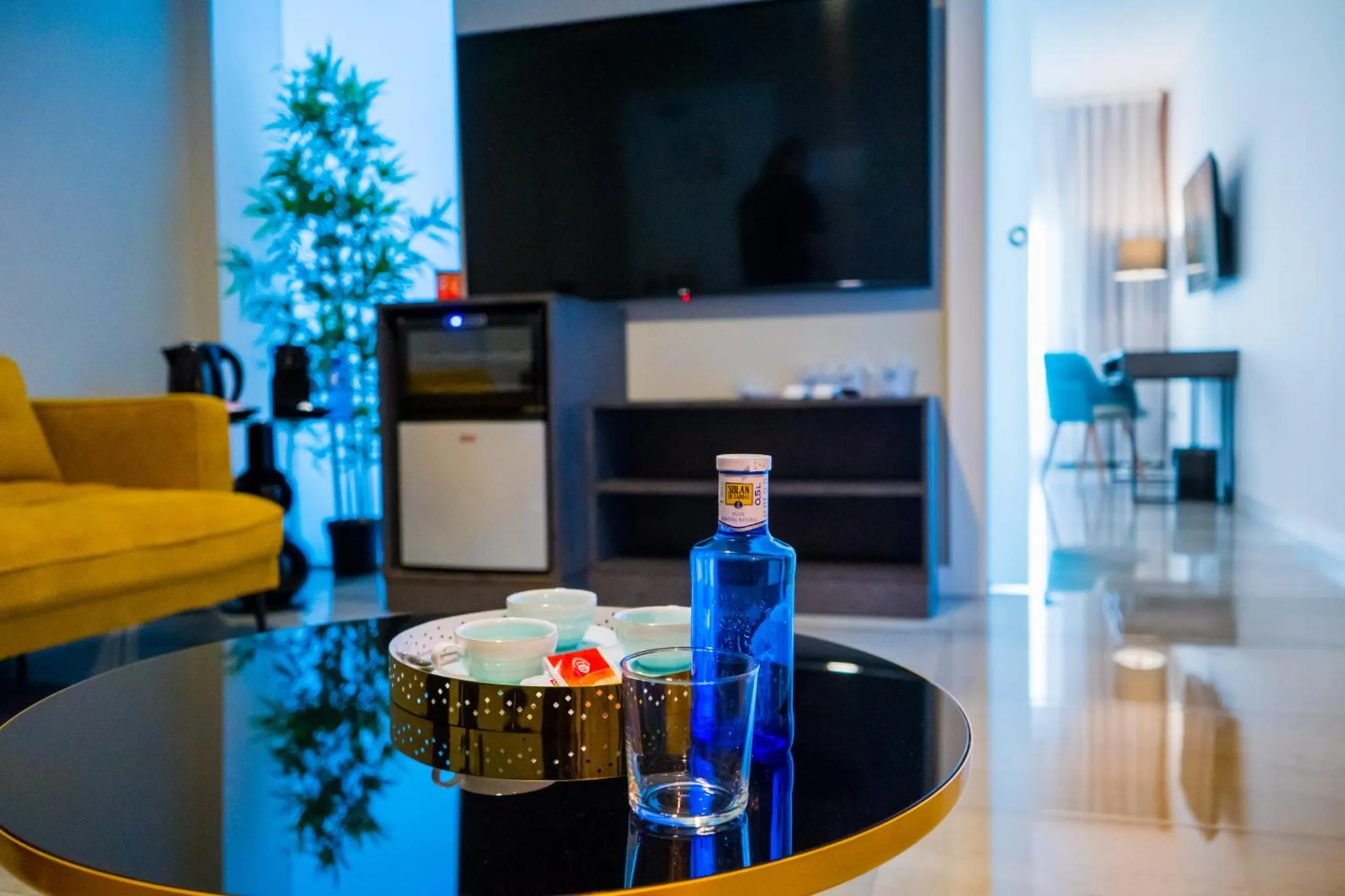 Une table basse avec des verres et une bouteille dans un espace de vie lumineux.