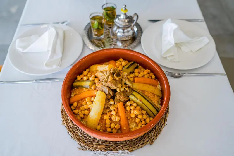 Un plat traditionnel est présenté sur une table nappée.