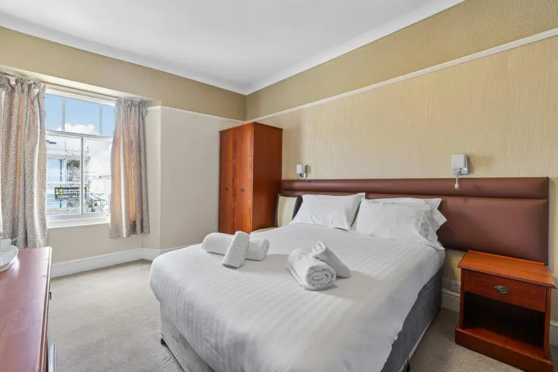 Une chambre lumineuse avec un lit double et une fenêtre.
