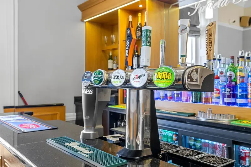 Un comptoir de bar présente des robinets à bière et des bouteilles.
