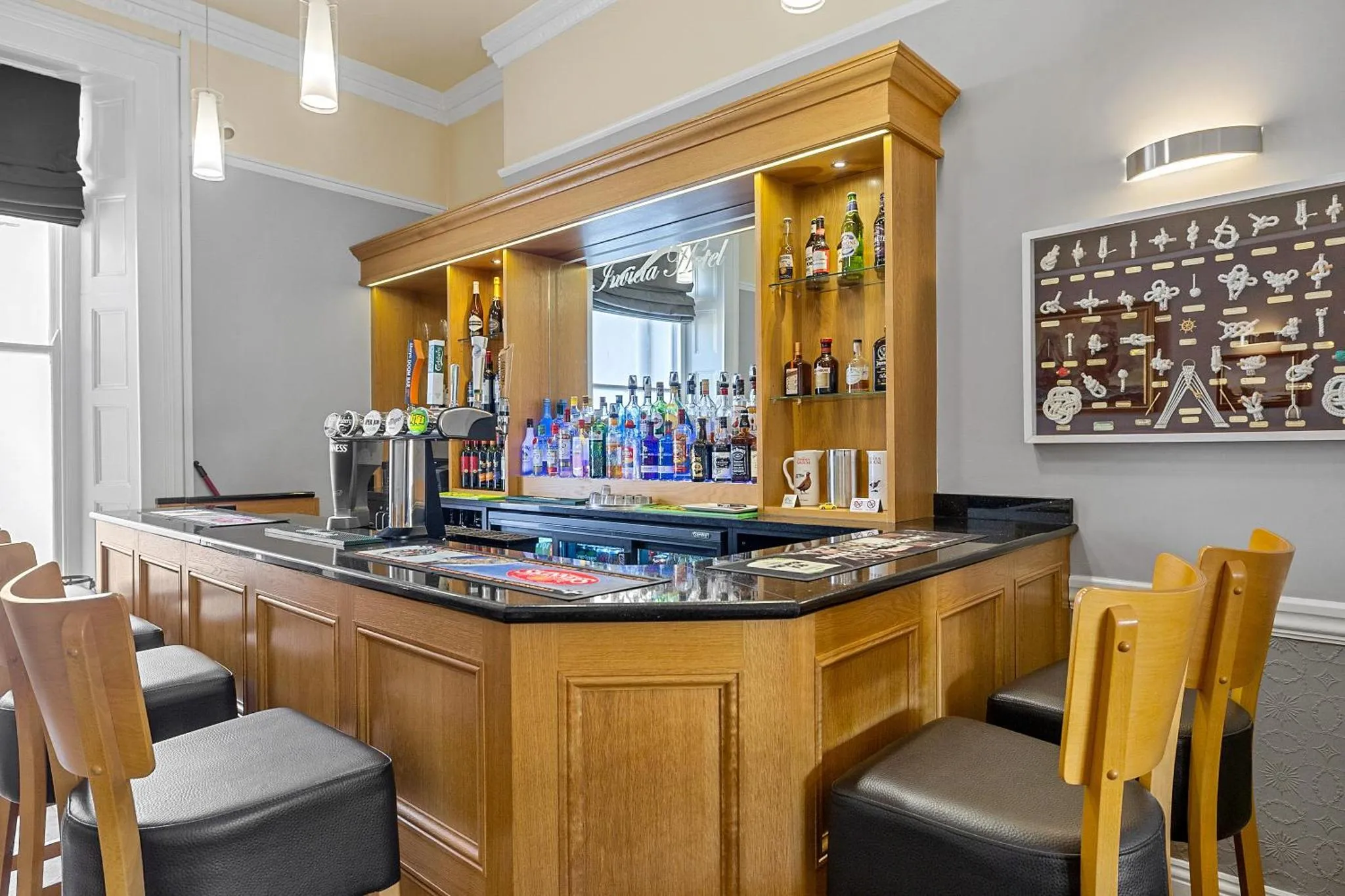 Un comptoir de bar en bois avec des bouteilles et des verres.