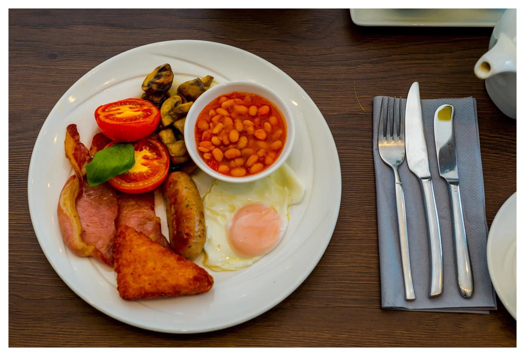 Assiette garnie d'un petit-déjeuner anglais avec œufs, haricots, tomates et bacon.