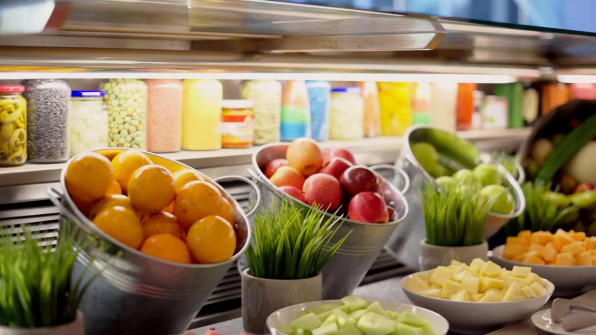 Présentation colorée de fruits frais et de céréales en vrac sur un buffet.