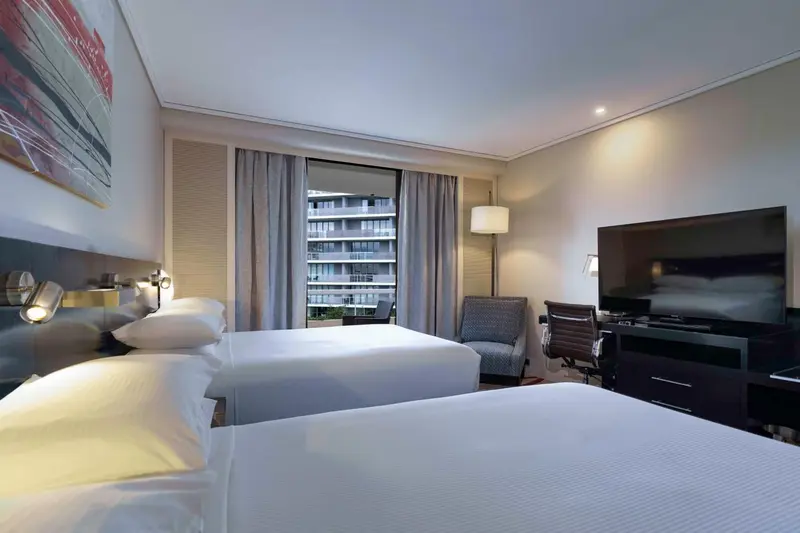 Chambre d'hôtel avec deux lits et vue sur la mer.