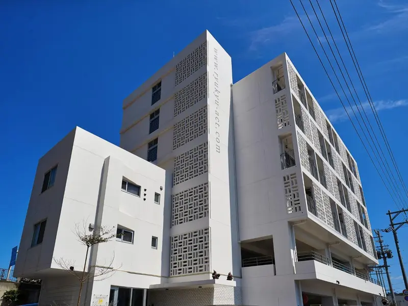 Façade d'un bâtiment moderne à plusieurs étages sous un ciel bleu.