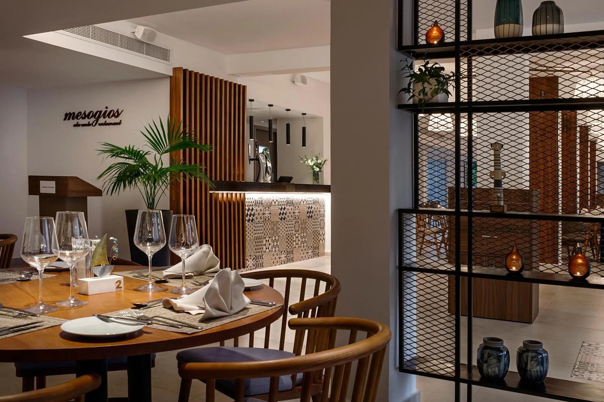 Une table de restaurant est dressée avec des couverts et de la vaisselle.