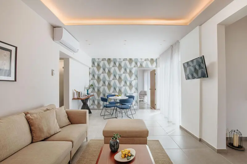 Espace de vie intérieur clair avec canapé et table à manger.