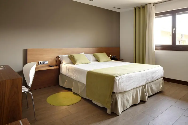 Une chambre lumineuse avec un grand lit et une décoration sobre.