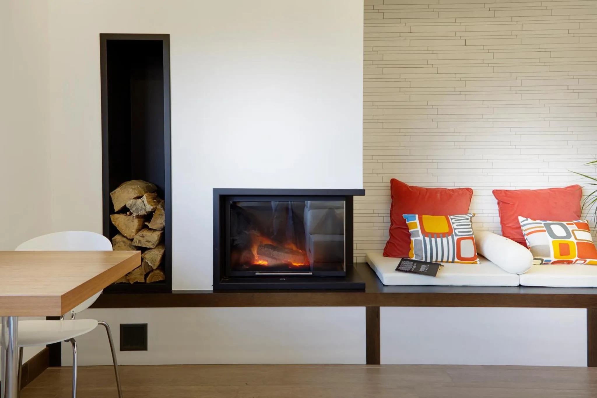 Cheminée moderne intégrée dans un espace de détente avec canapé et table.