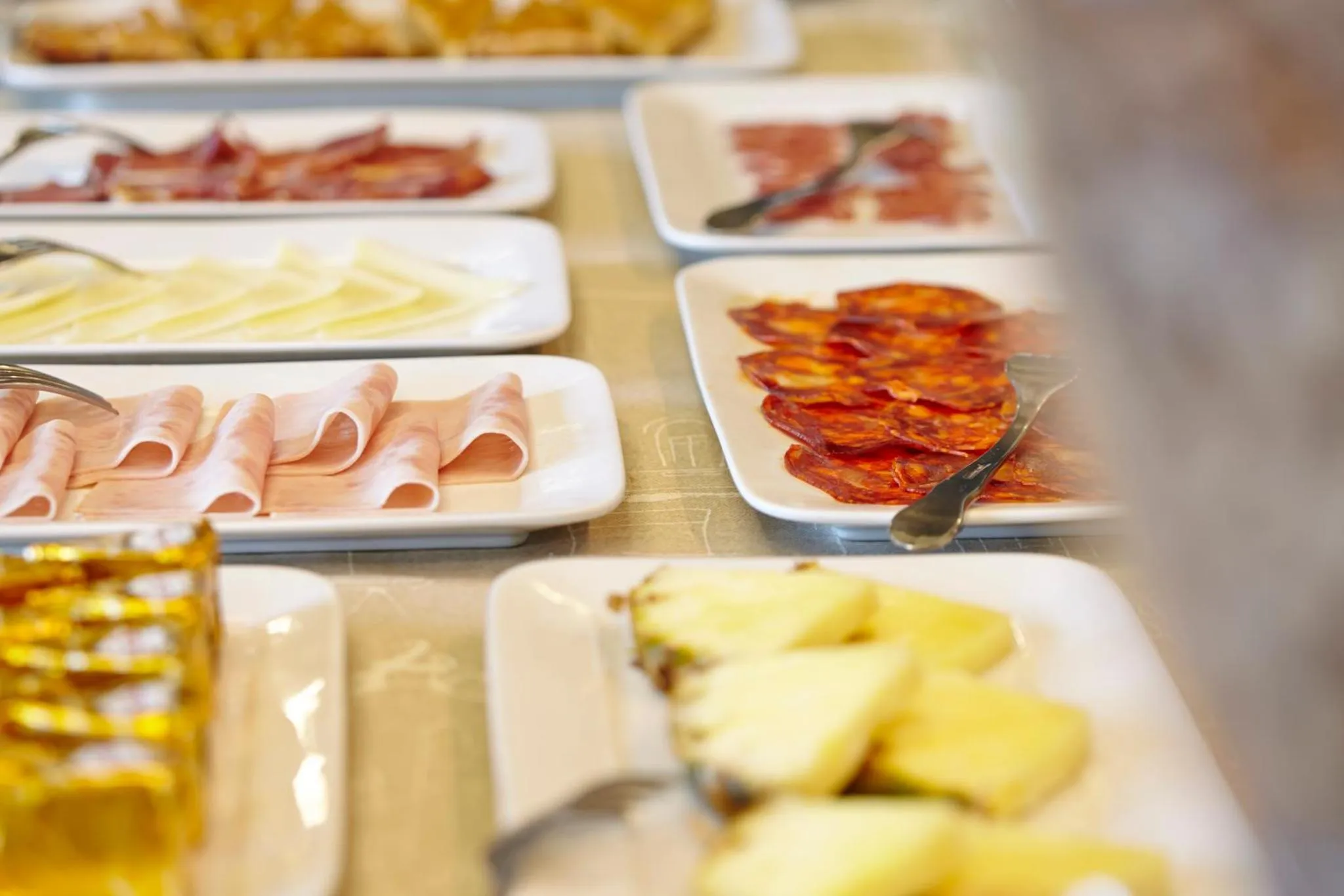 Présentation de charcuteries et de fromages variés sur un buffet.
