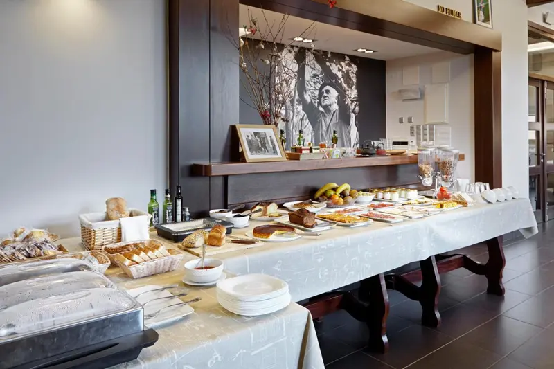 Un buffet propose des viennoiseries, des fruits et des pâtisseries sur une longue table recouverte d'une nappe blanche.