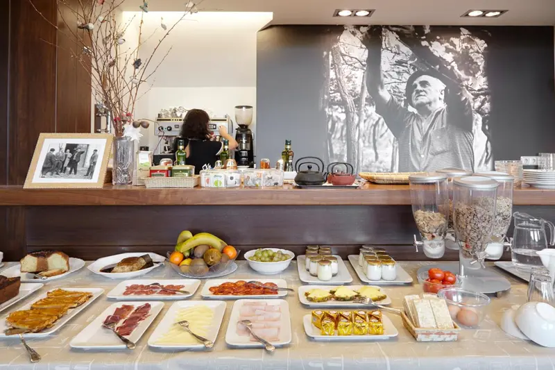 Un comptoir de buffet propose des viennoiseries, des fruits et des charcuteries.