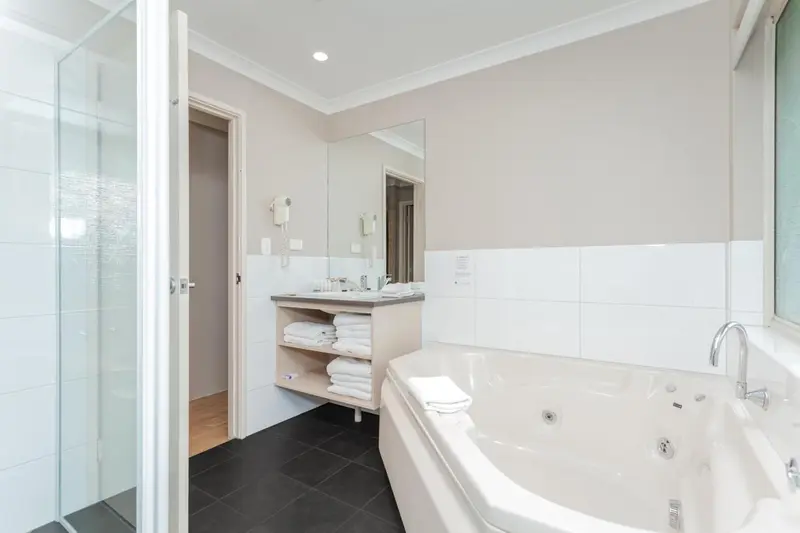 Une salle de bain lumineuse avec baignoire et douche à l'italienne.