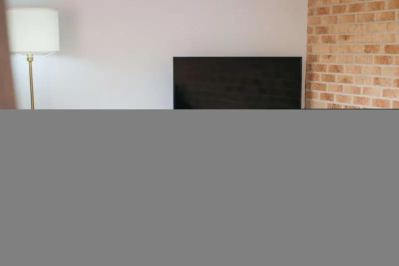 Une télévision est fixée au-dessus d'une cheminée en briques.
