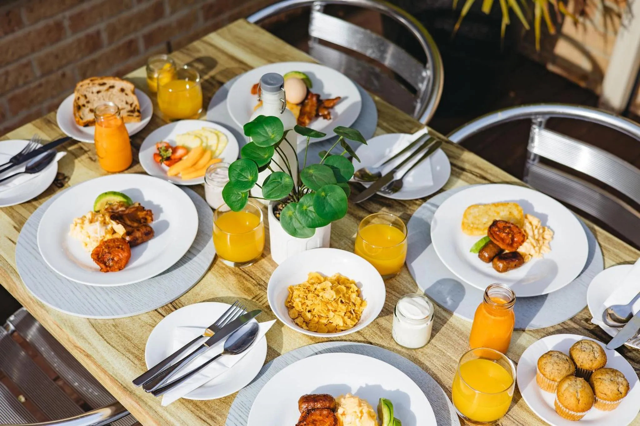 Une table est dressée avec des assiettes garnies de divers plats et boissons.