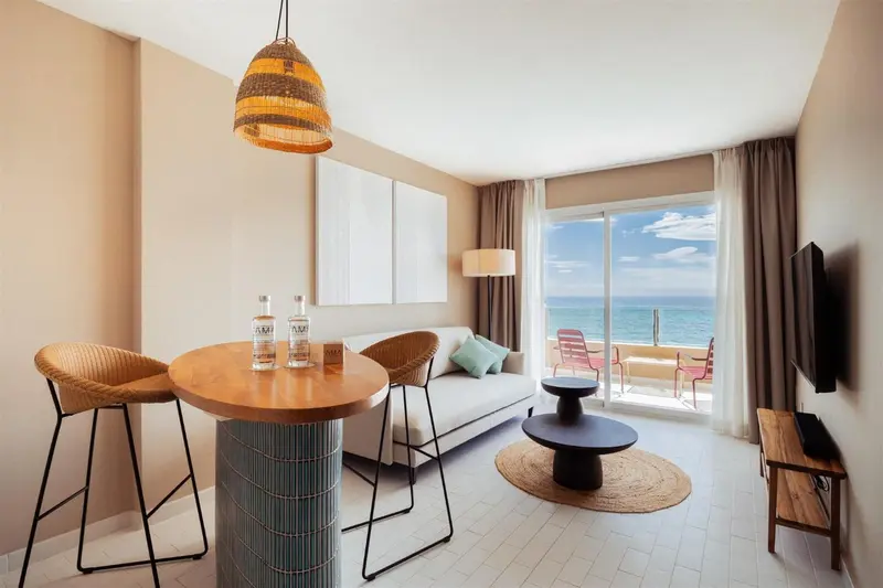 Espace de vie lumineux avec coin repas et vue sur la mer.