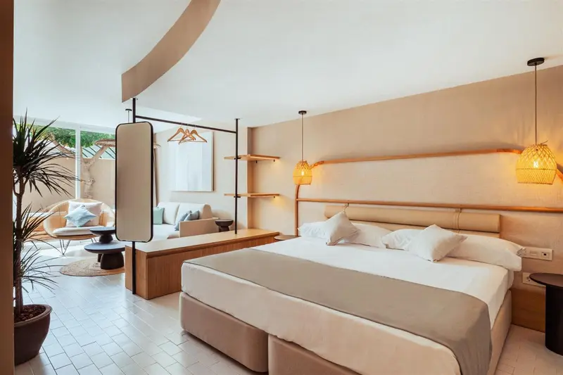 Une chambre lumineuse avec un grand lit et un espace détente.