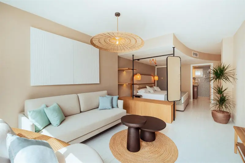 Espace de vie intérieur lumineux avec canapé et lit.