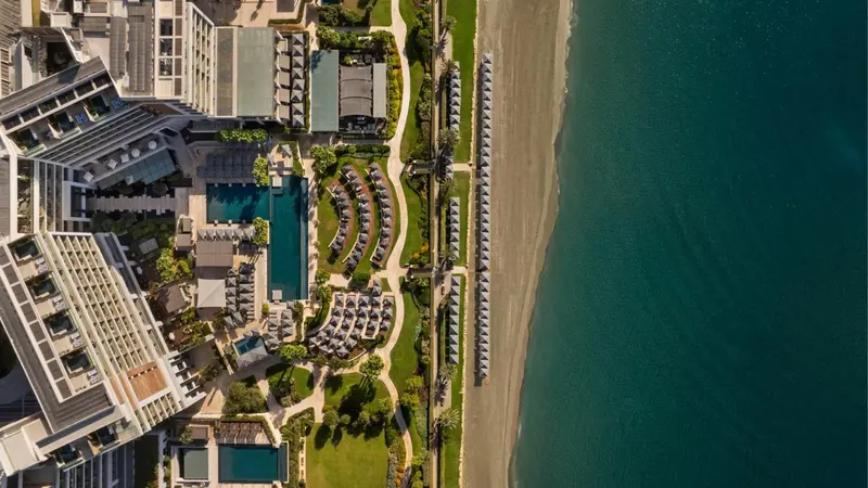 Vue aérienne d'un complexe hôtelier avec piscine et plage.