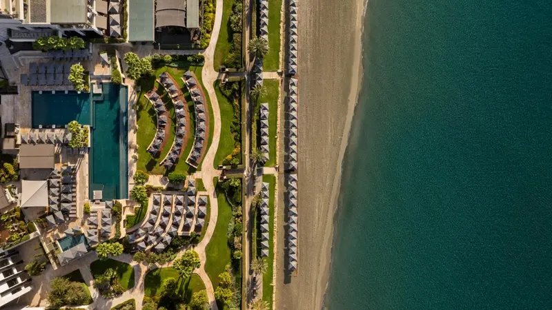Vue aérienne d'un complexe hôtelier avec piscine et plage.