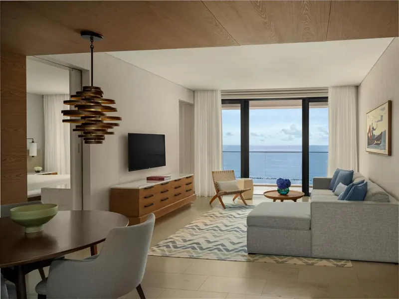 Un salon lumineux avec canapé et table basse donne sur la mer.