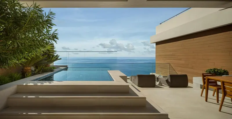 Terrasse avec piscine à débordement donnant sur l'océan.