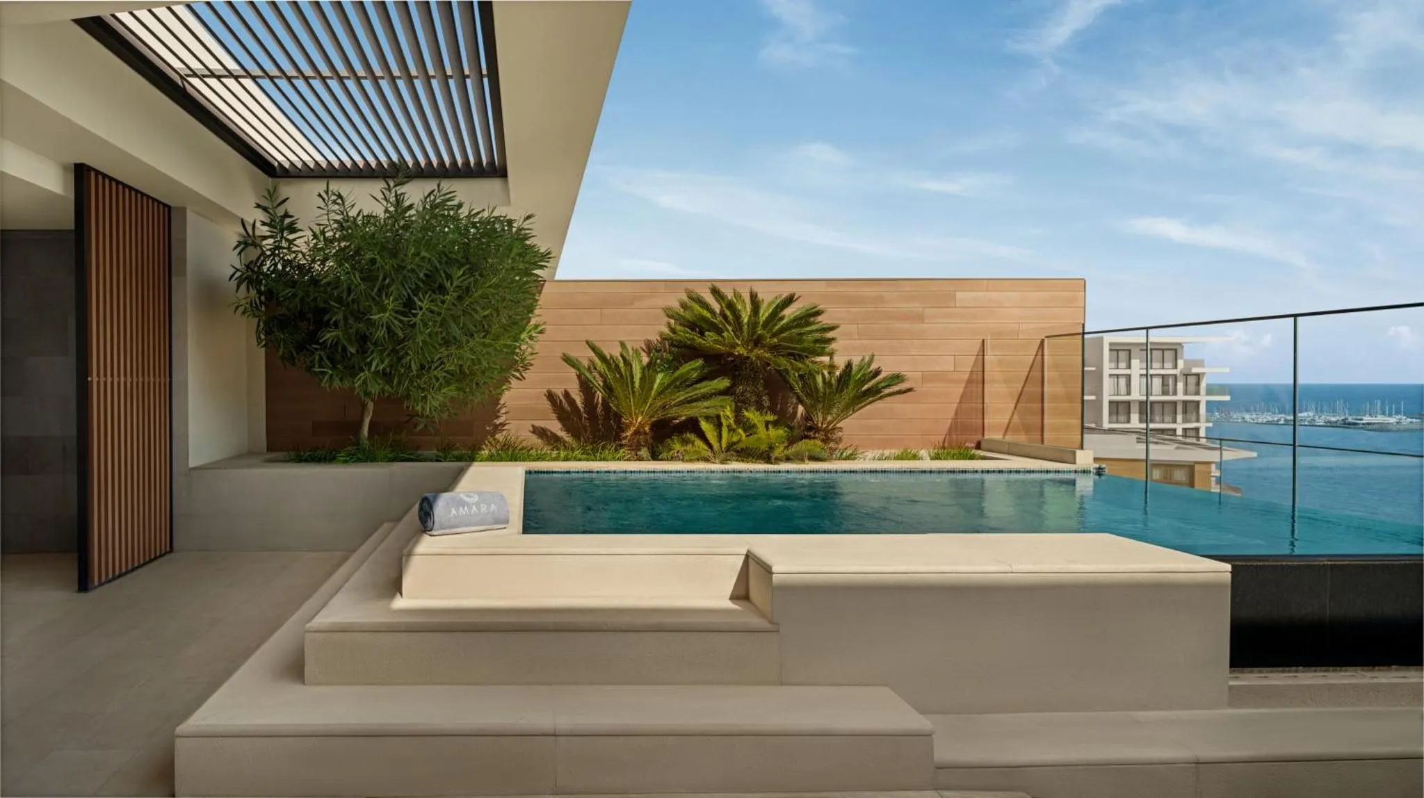 Une piscine à débordement offre une vue sur la mer depuis une terrasse aménagée.