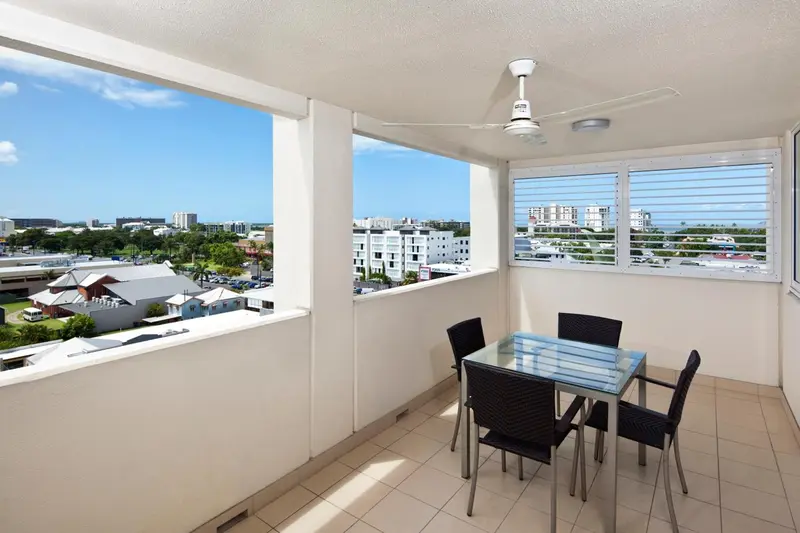 Une terrasse avec une table et des chaises offre une vue sur la ville.