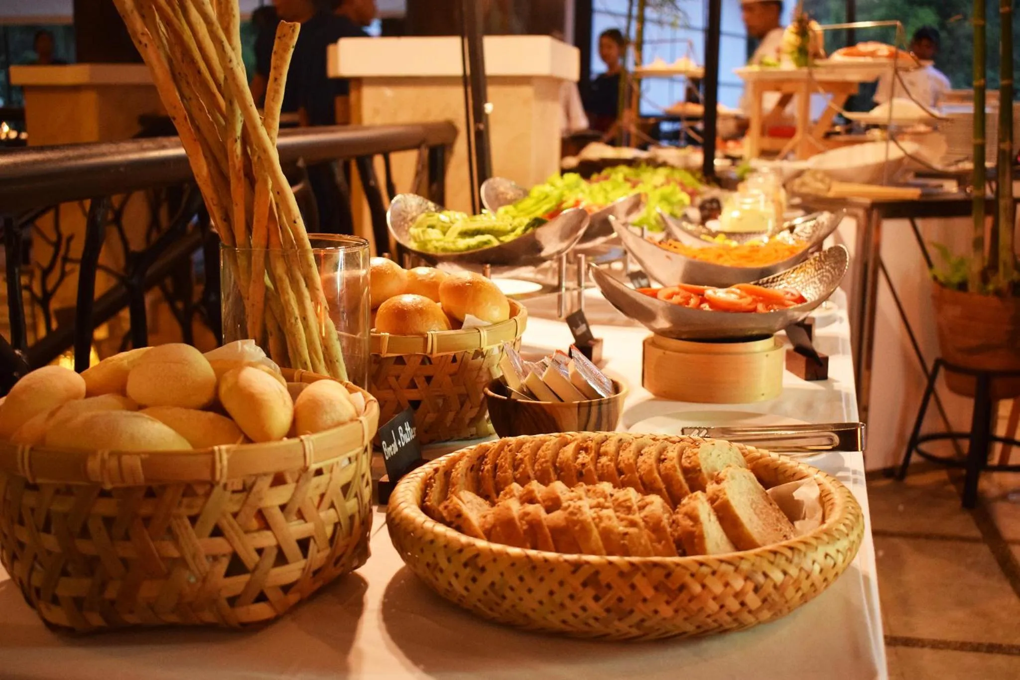 Un buffet propose une variété de pains et de salades.