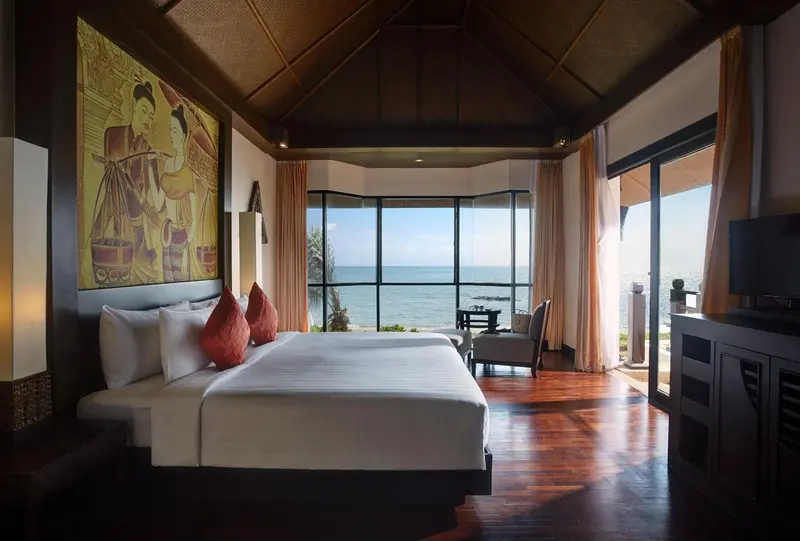 Une chambre lumineuse avec un grand lit donnant sur la mer.