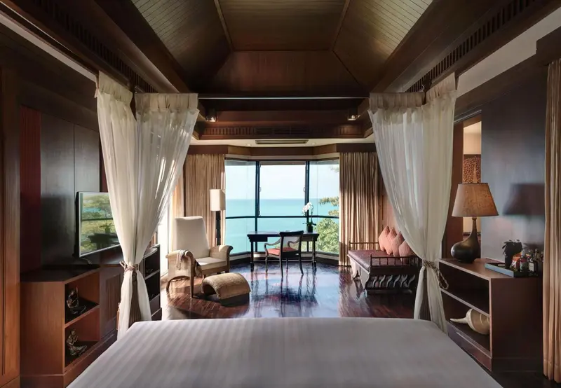 Chambre avec un grand lit et une vue sur la mer.
