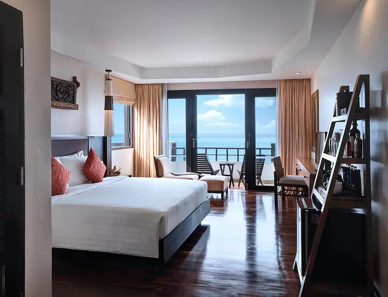Une chambre lumineuse avec un grand lit et une vue sur la mer.