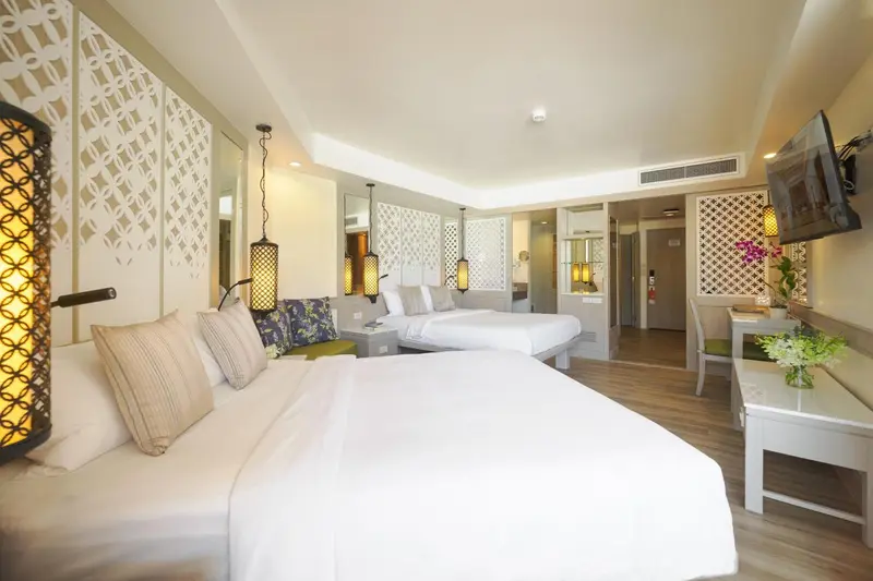 Chambre lumineuse avec deux lits simples et décoration florale.