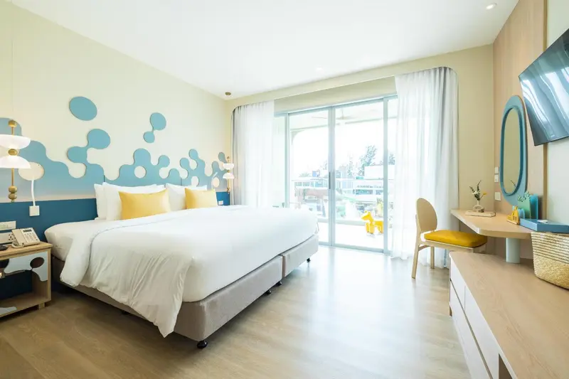 Une chambre lumineuse avec un grand lit et un accès à une terrasse.
