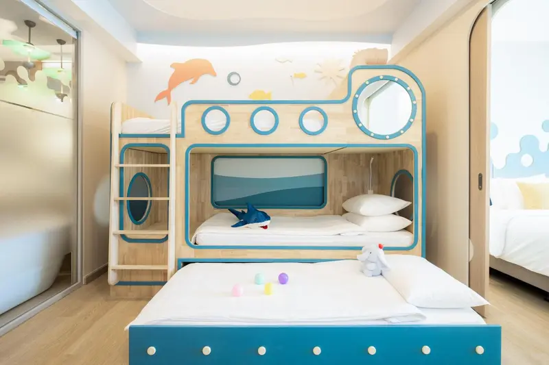 Chambre d'enfants décorée sur le thème marin avec un lit superposé.