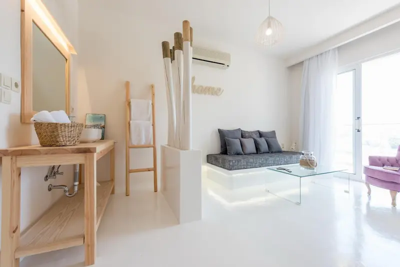 Intérieur lumineux avec un coin salon et un meuble-lavabo en bois.
