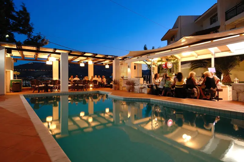 Terrasse lumineuse avec piscine et clients attablés.