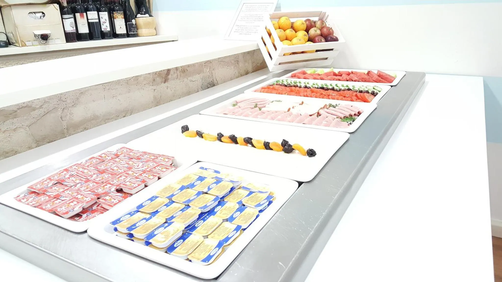 Présentation de charcuterie, de fruits et de viennoiseries sur un buffet.