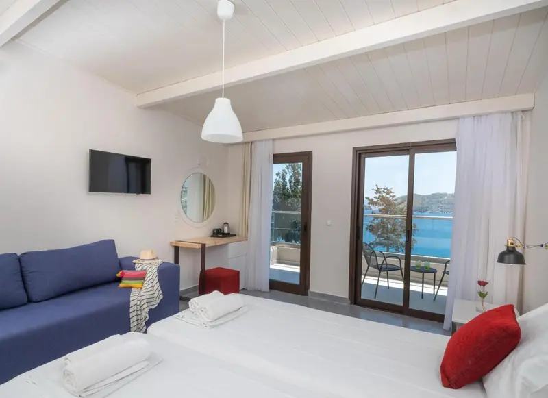 Une chambre lumineuse avec un canapé bleu et un accès à un balcon.