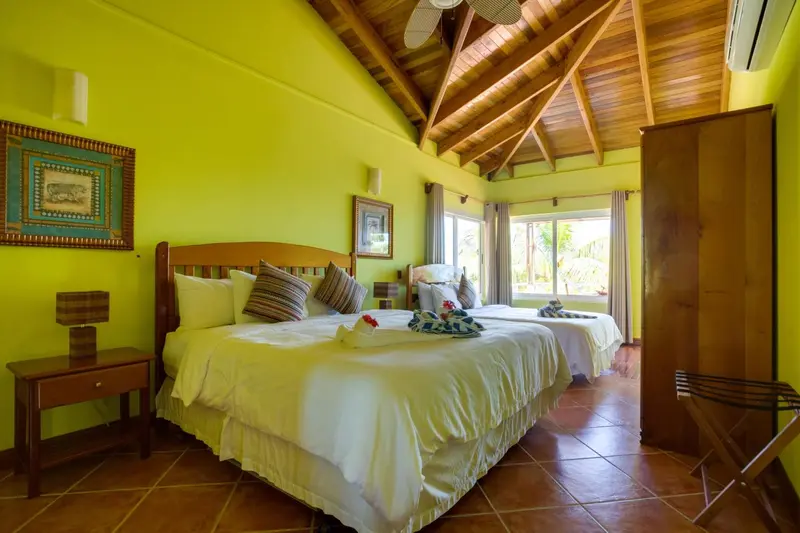 Une chambre lumineuse avec deux lits simples et une décoration colorée.