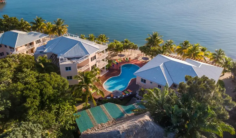 Vue aérienne d'un complexe hôtelier avec piscine et végétation tropicale.
