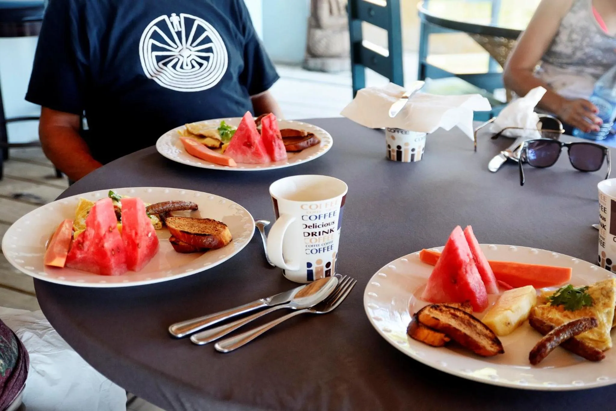 Une table est dressée avec des assiettes de fruits et de nourriture.