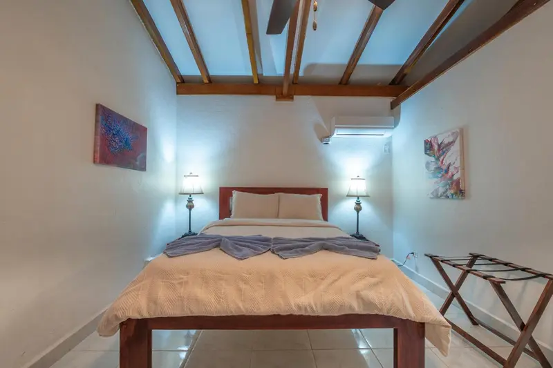 Une chambre lumineuse avec un lit double et des lampes de chevet.