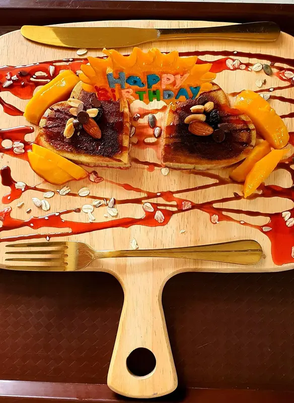 Assiette de dessert décorée avec des fruits et un message d'anniversaire.