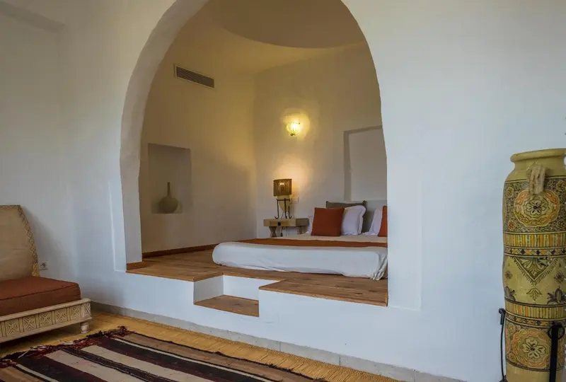 Une chambre lumineuse avec un lit intégré dans une alcôve.