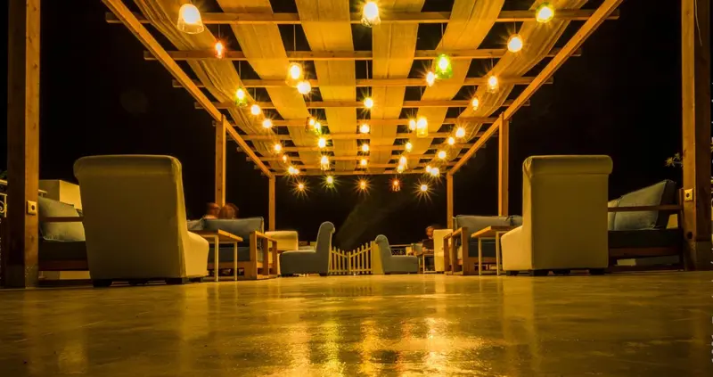 Espace de détente extérieur illuminé avec des fauteuils confortables.