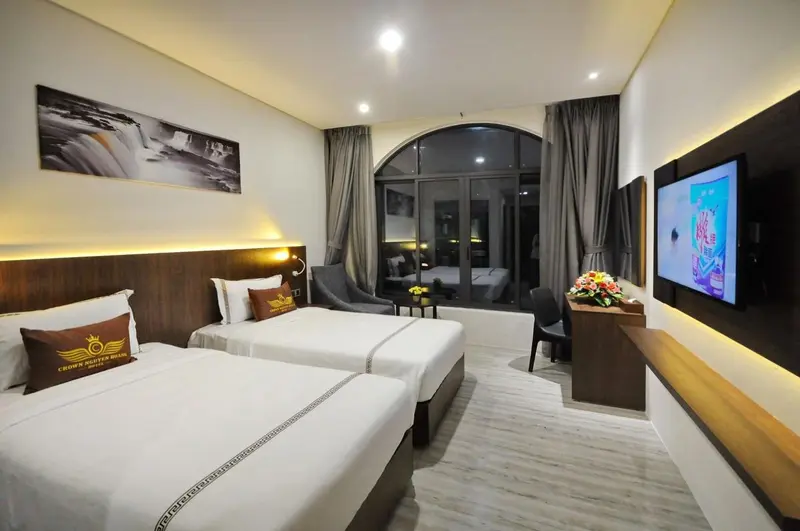 Chambre lumineuse avec deux lits simples et une grande fenêtre.