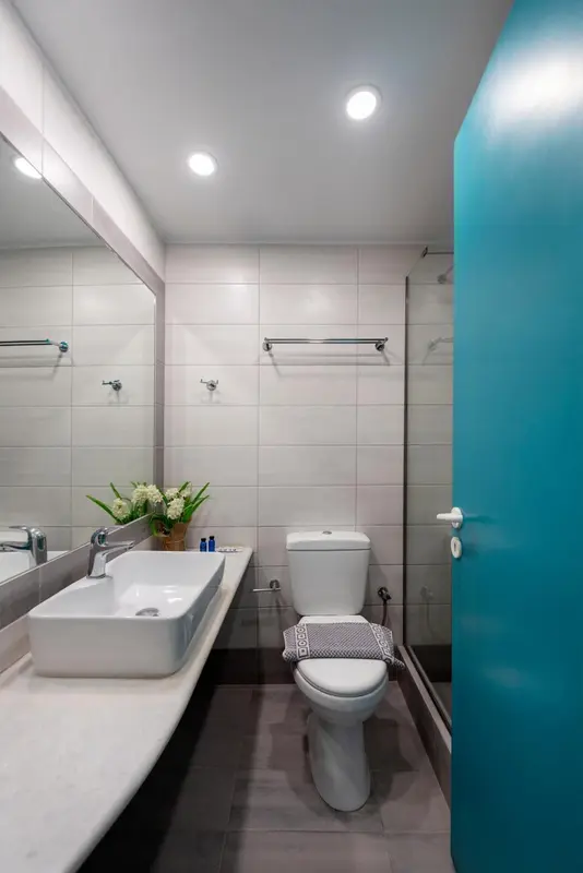 Une salle de bain moderne avec carrelage clair et sanitaires blancs.