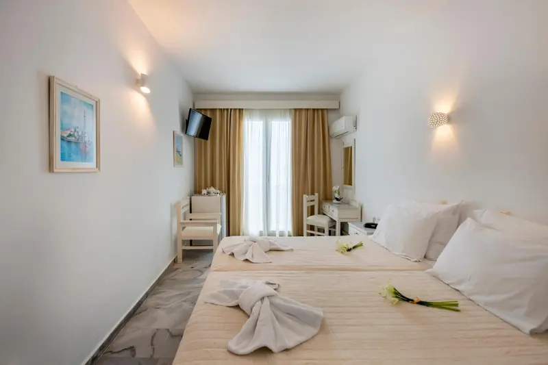 Chambre lumineuse avec deux lits simples et décoration sobre.