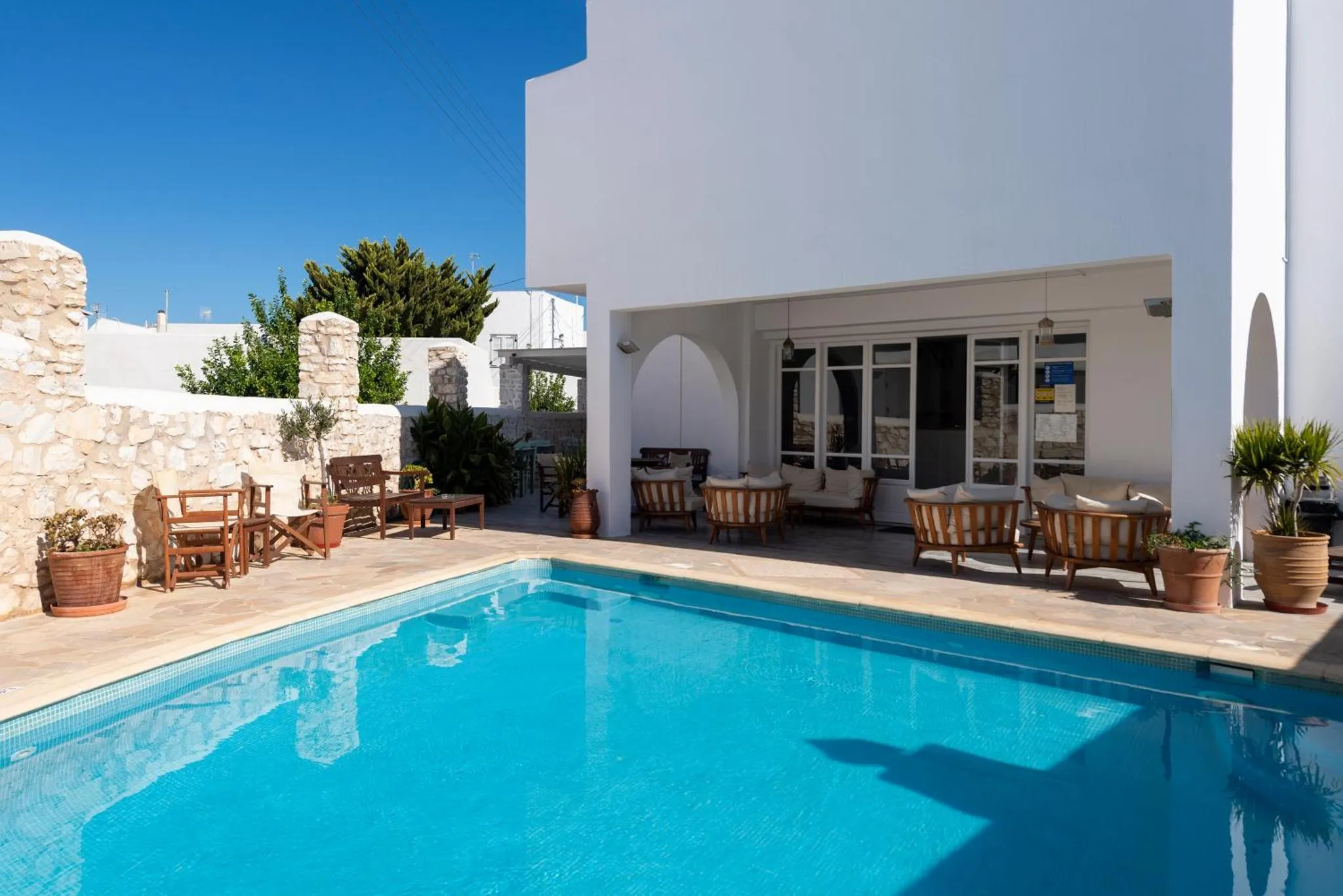 Terrasse avec mobilier de jardin et piscine ensoleillée.